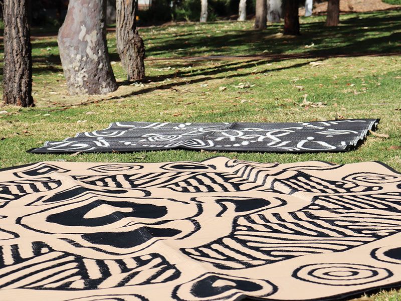 Two Yarning mats on a lawn.