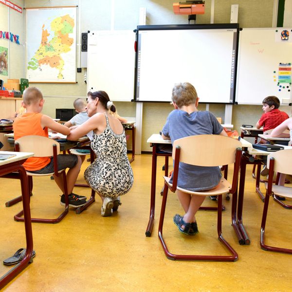 Teacher helping a student in a classroom. Game changer: Up to $40,000 teaching scholarships now available