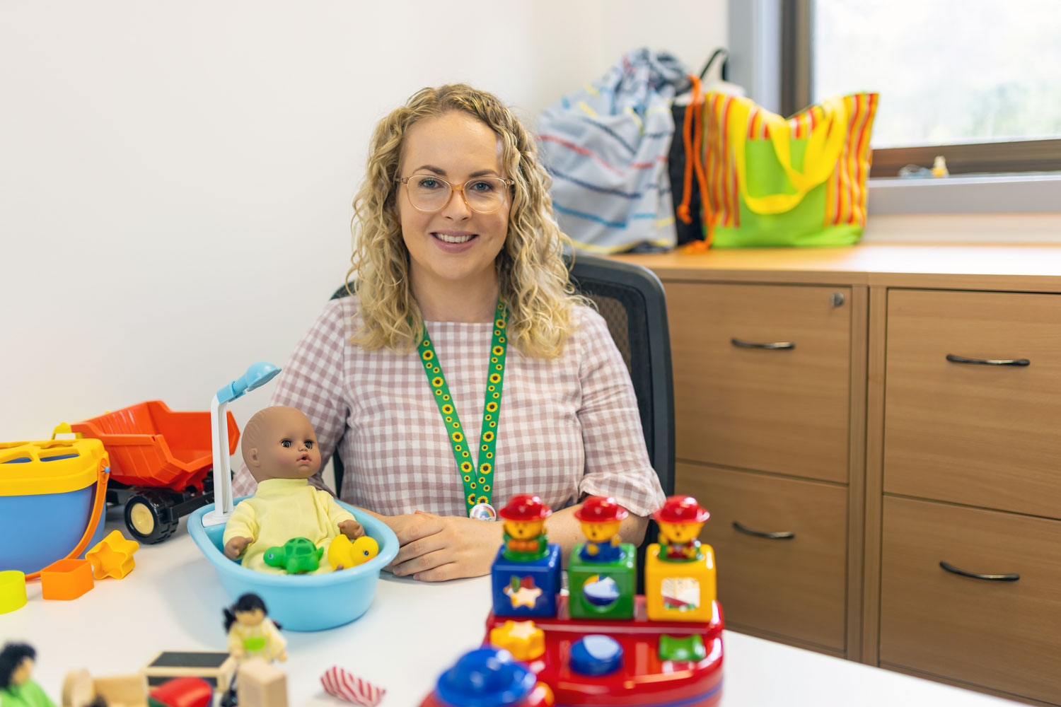 Olivia Whalen at her lab desk with children's toys