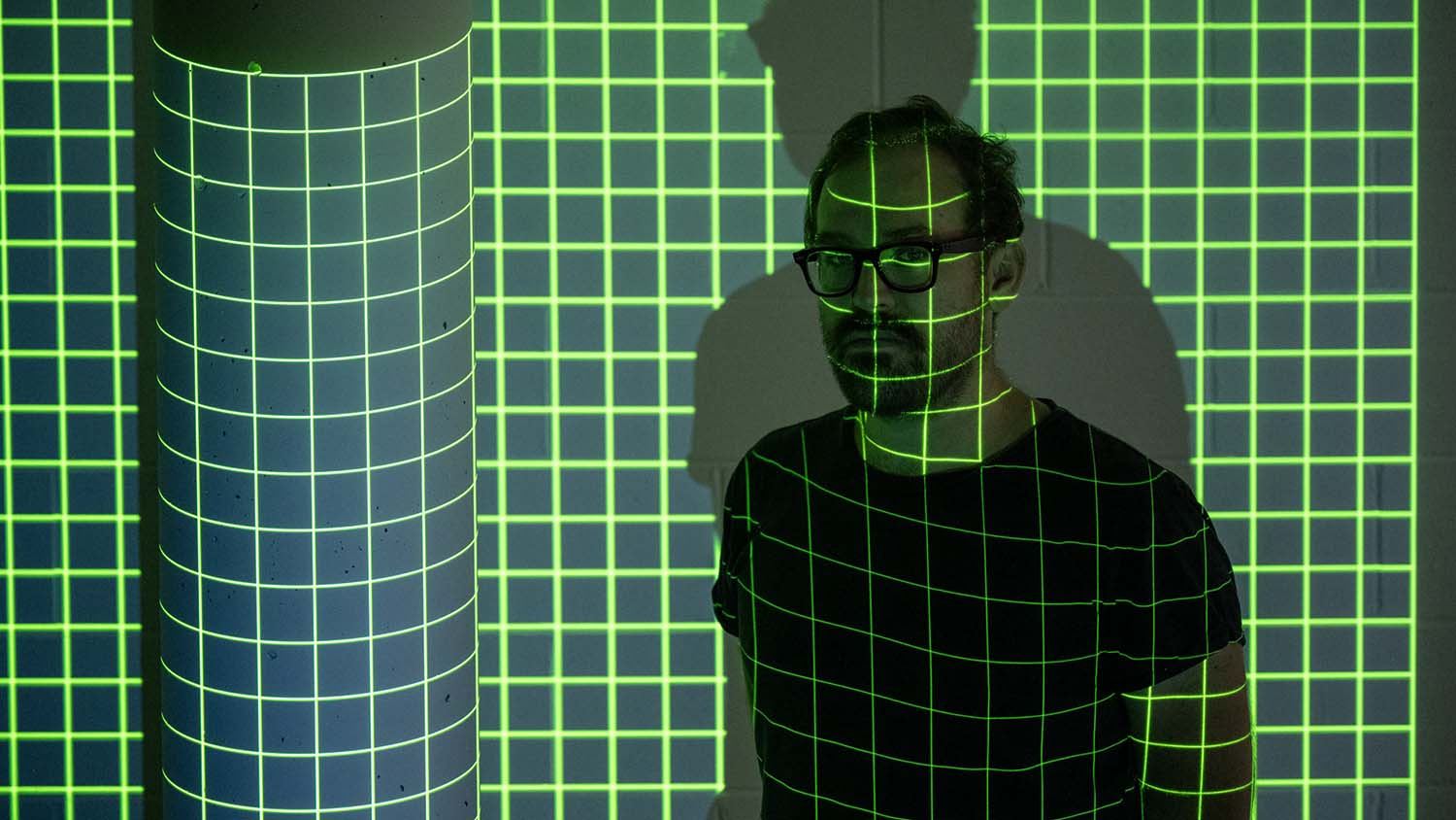 Dr Nicholas Foulcher standing in a grid of illuminated lines