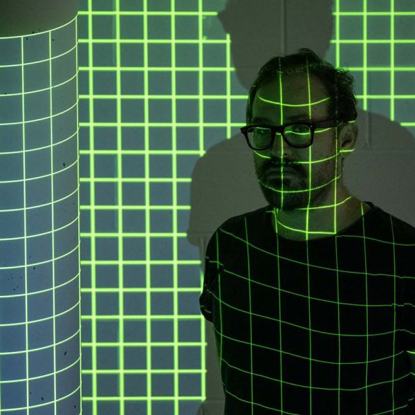 Dr Nicholas Foulcher standing in a grid of illuminated lines
