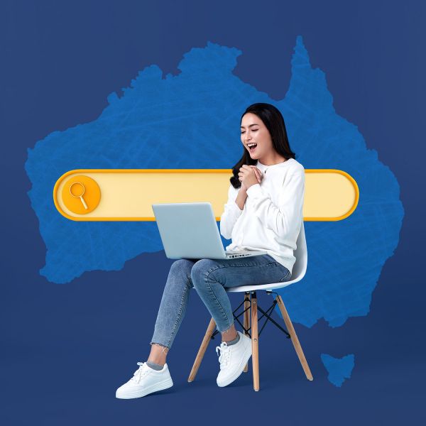 A woman sitting in a chair with a laptop in front of a map of Australia.