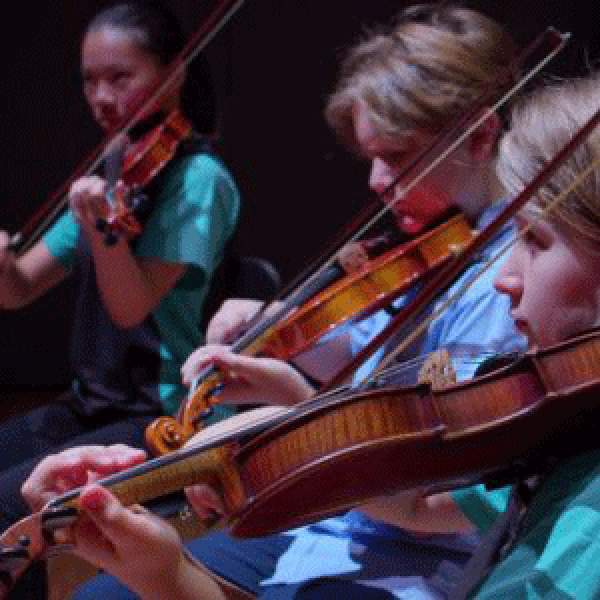 Children playing violin on stage