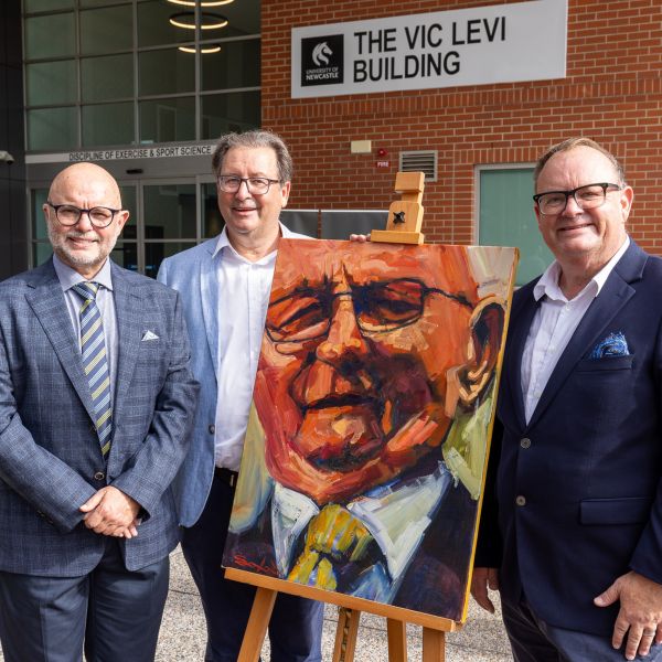 Vic Levi's three sons gather around the commissioned painted portrait of the late Vic Levi, underneath the new 