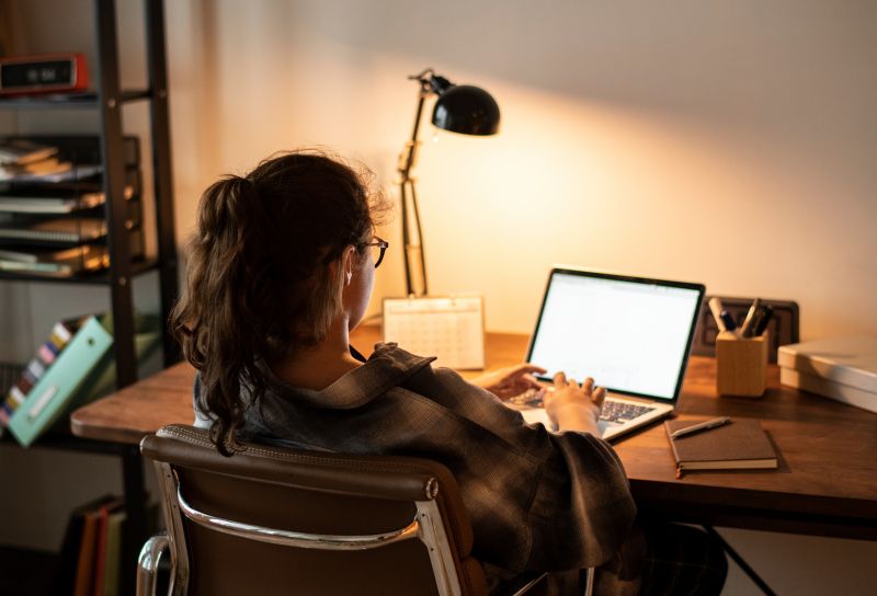 Woman working on a laptop at her desk at home