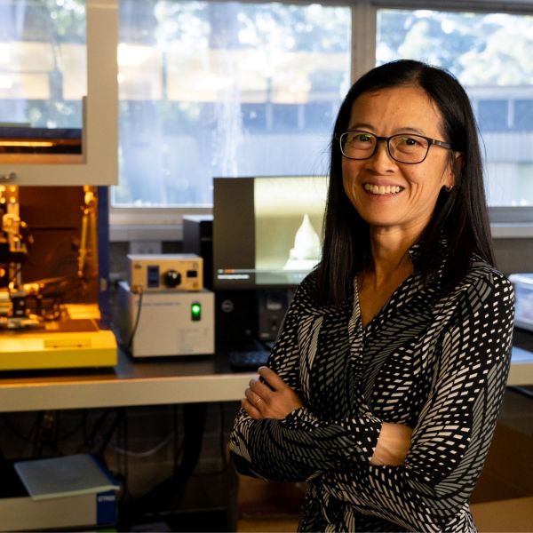 Associate Professor Yuen Yong smiles to camera with lab equipment in the background. Pulsating microneedles painless alternative to traditional needles .