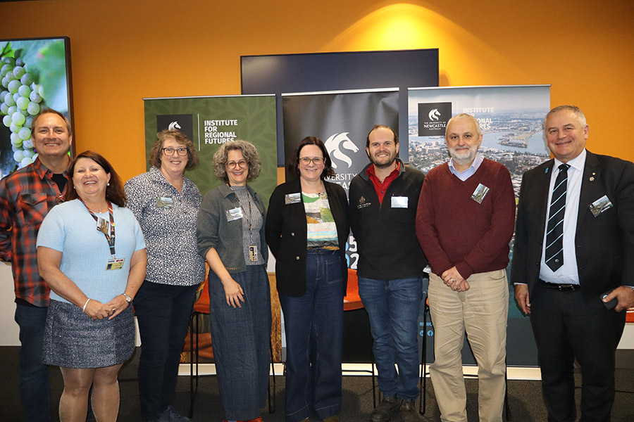 Group of people in front of banners and smiling for the camera