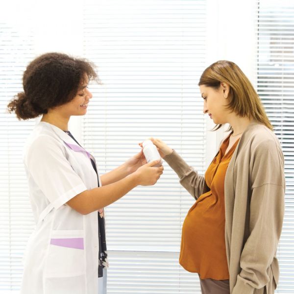Midwife showing a pregnant woman bottled medication