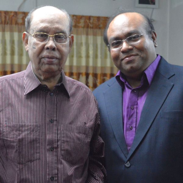 two men (father and son) standing side by side, smiling to camera. Why I donate
