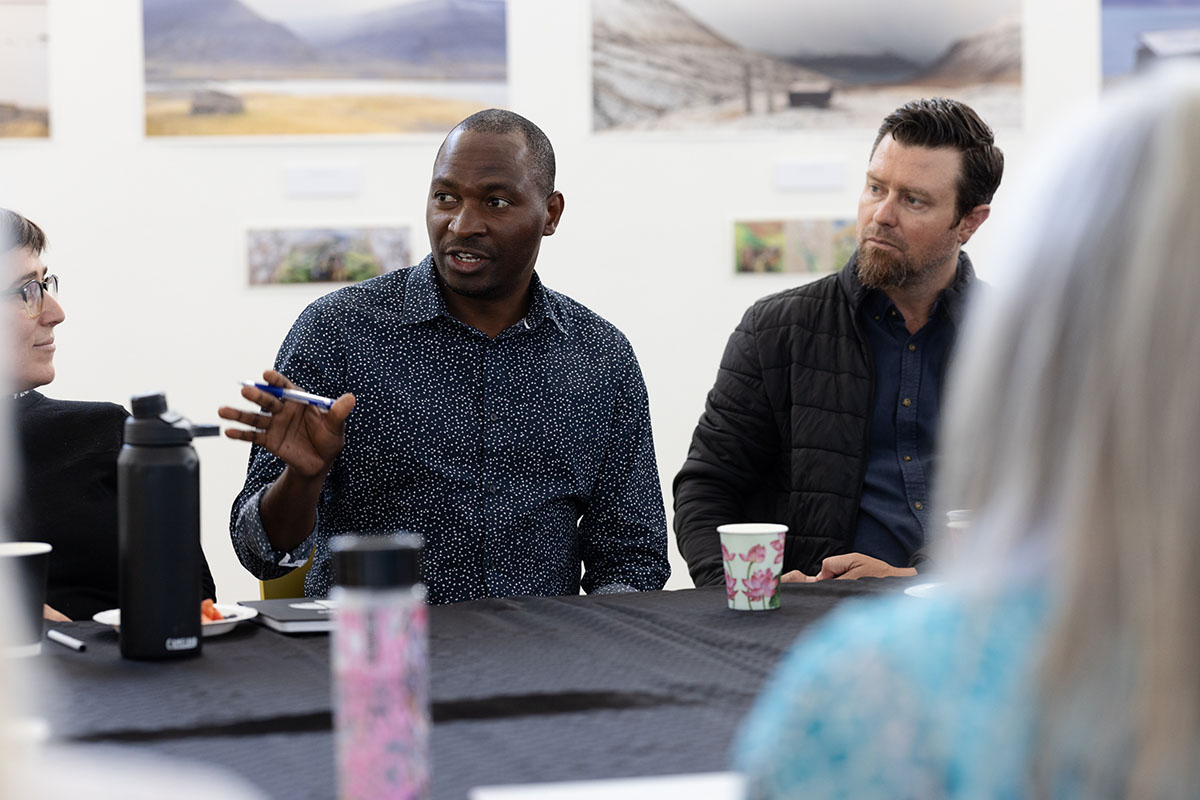 A man talking at a table amongst a group