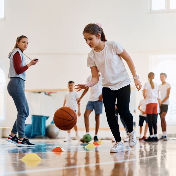Student bounces a basketball in school sports lesson. Exercise for students with disability boosts wellbeing beyond the classroom