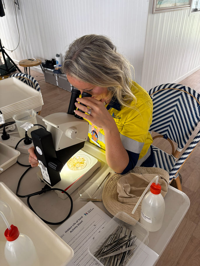 City of Newcastle staff member looks through a microscope at a table