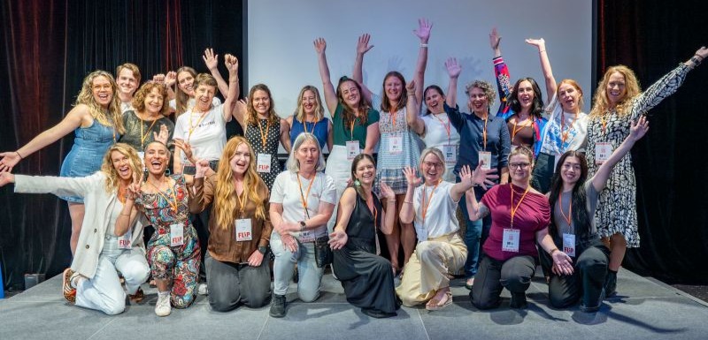Group of women smiling & raising their arms in celebrations