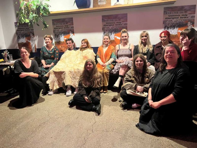 A group of young adults looking happy, one wearing a possum skin cloak