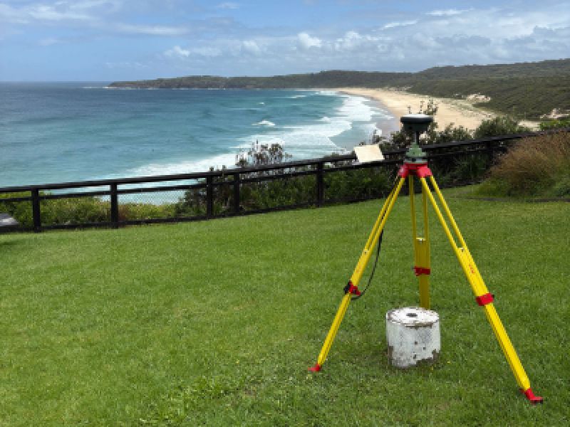 Image of surveying equipment on hill overlooking the breach on a sunny day
