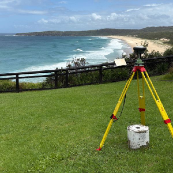 Image of surveying equipment on hill overlooking the breach on a sunny day