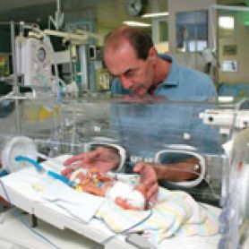 Professor Roger Smith with a baby in an incubator. HMRI Professor Roger Smith is named Member of the Order of Australia