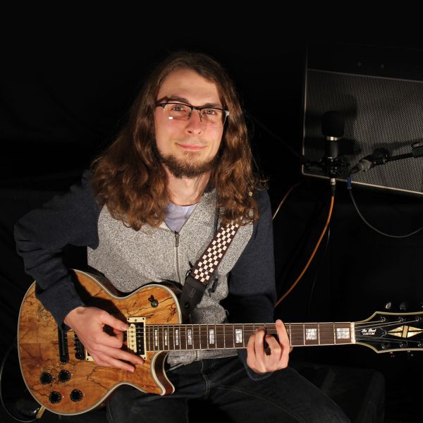 Alex with guitar. Engineering a mechatronics career music to Alex’s ears