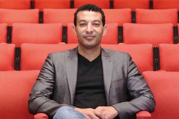 Image of a man sitting in an empty auditorium