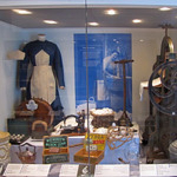 Inside the Shetland Museum and Archives: Display of uniform and devices used by domestic servants. Servants Past 