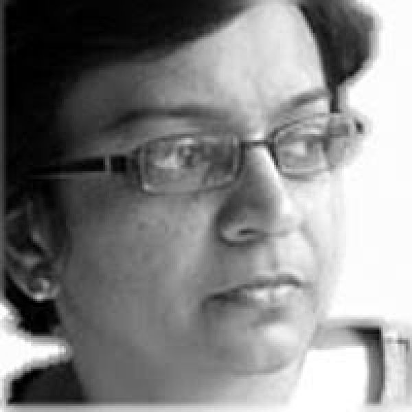 Black and white image of Indian woman in glasses looking to right of frame
