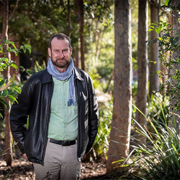 An image of Professor Kent Anderson standing on campus looking into the camera