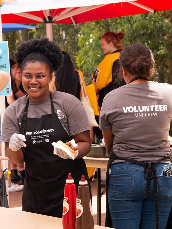 Picture of Uni Crew member volunteering at a BBQ on-campus