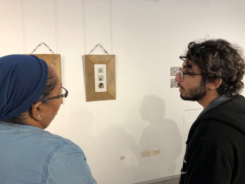 Two people looking at artwork in a gallery and talking to each other