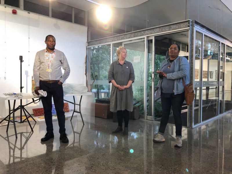 Three people in an art Gallery addressing an audience