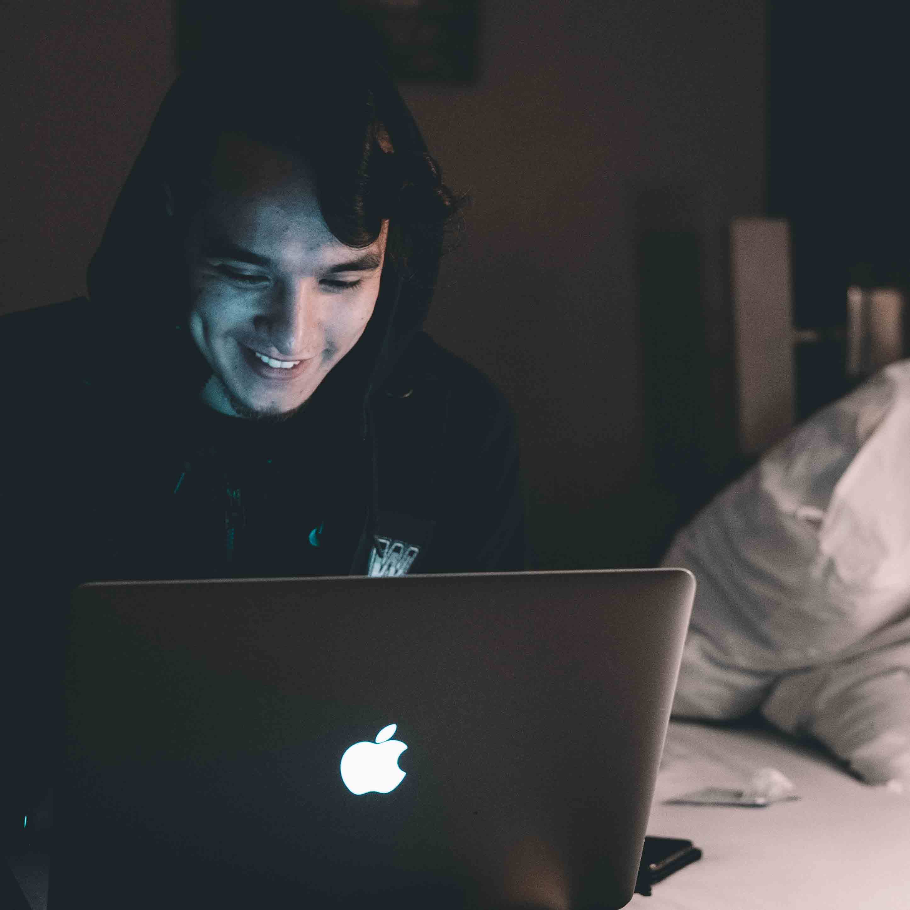 Boy sitting in the dark with a laptop