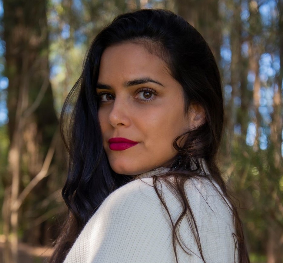 Hanna is pictured wearing red lipstick smiling - looking over her shoulder. 