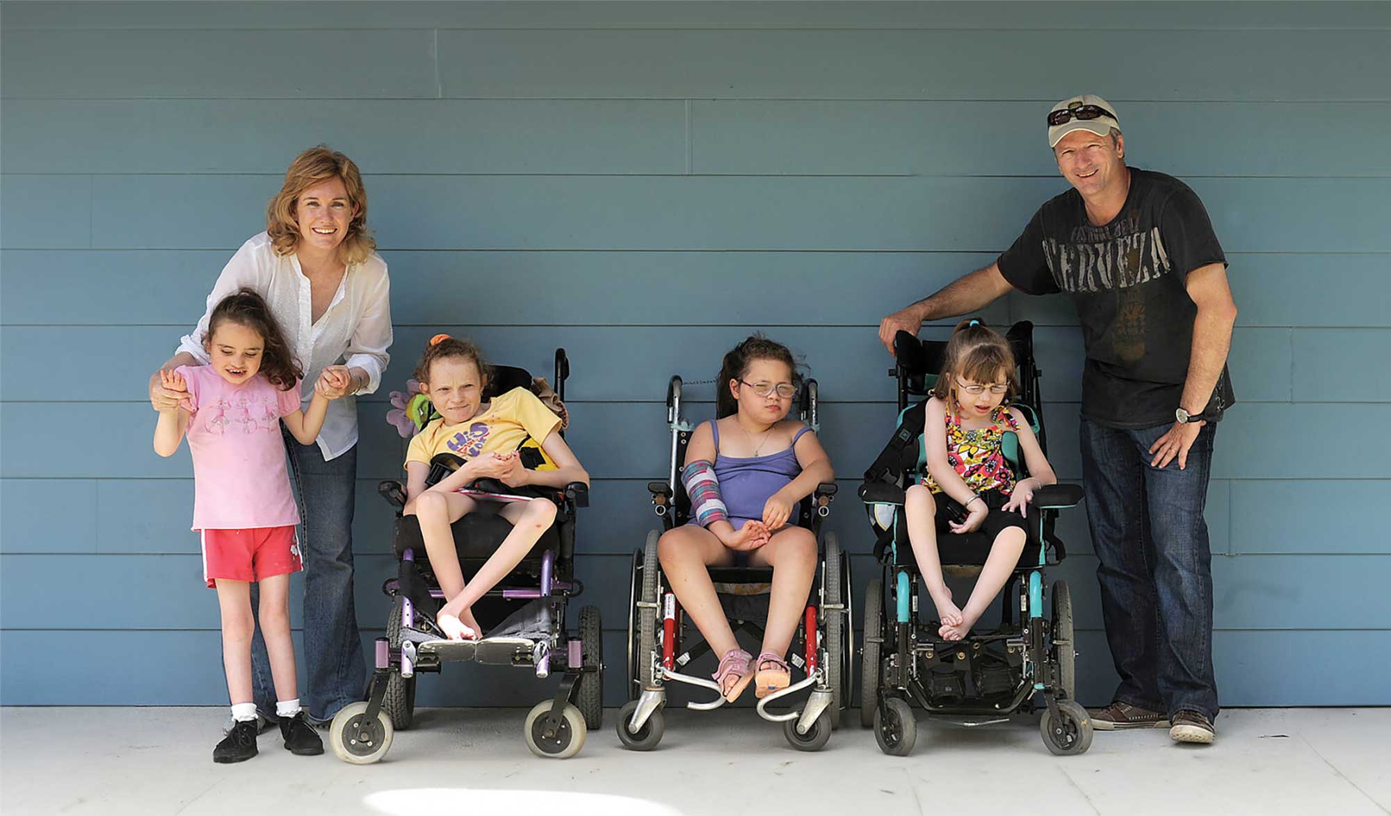 Lynette Waugh OAM and Steve Waugh AO with children at one of the SNUG retreats. A group, including children in wheelchairs, looking at the camera