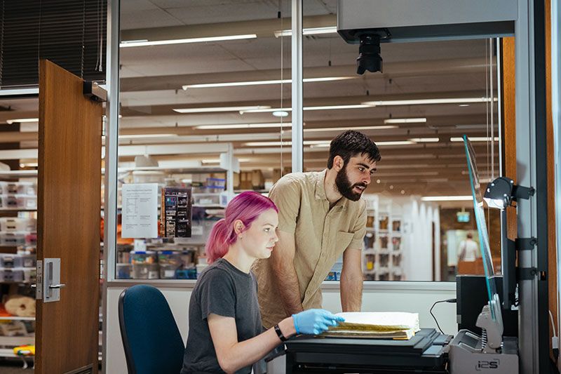 Two users digitisating a rare book