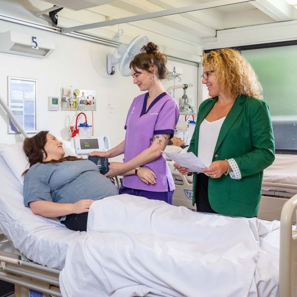 student, Nicole, pictured in a hospital setting assisting a patient. Midwifery research delivers insight into student learning .