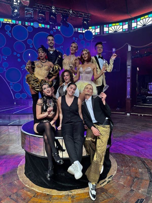 Young woman poses with the cast of circus show Blanc de Blanc in the Spiegeltent