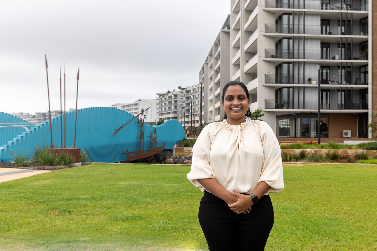 Dr Buddhini Ginigaddara standing in front of newly constructed buildings at Honeysuckle