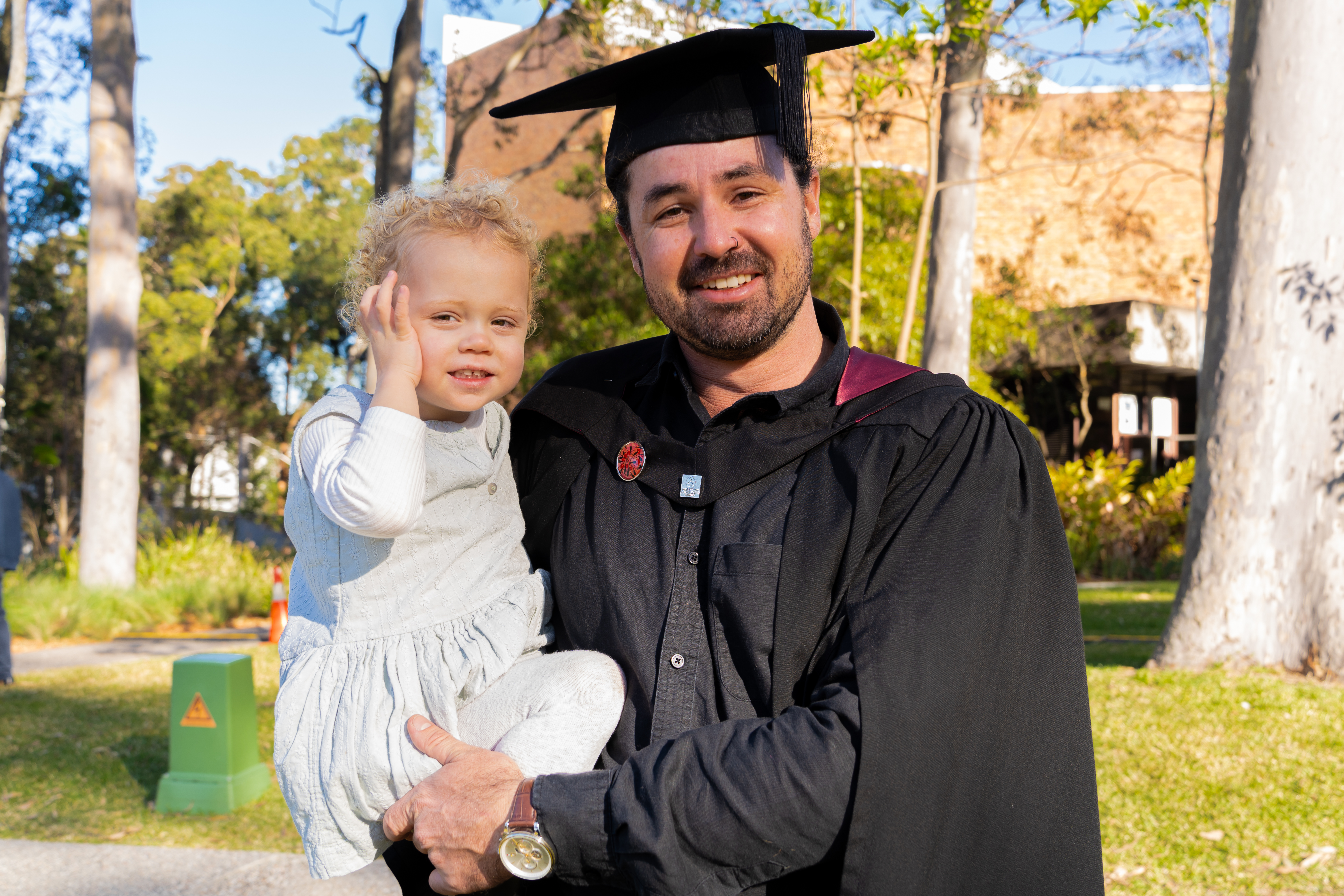Brendan in his graduation gown with his daughter Billie