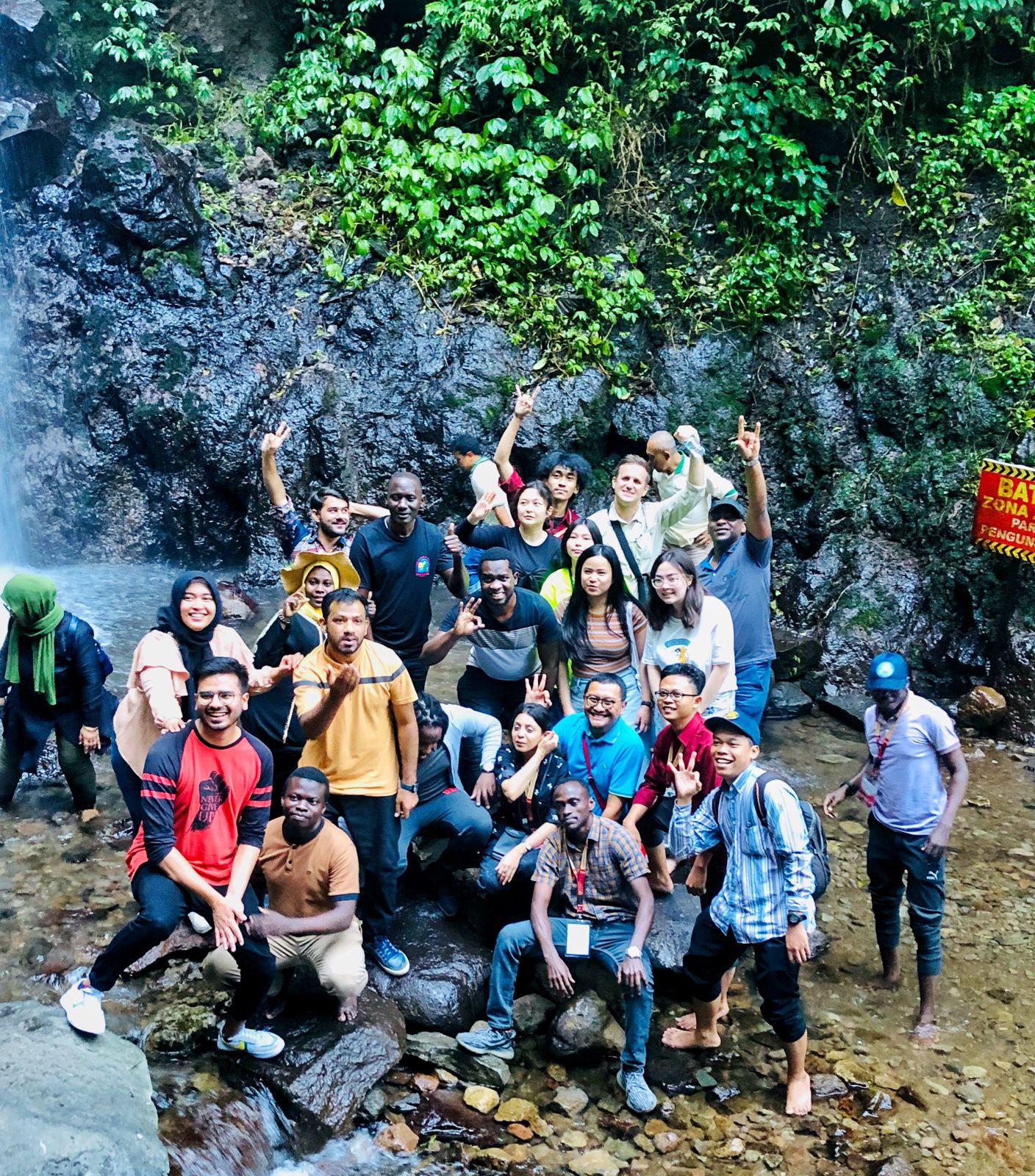 Big group of students near a waterfall in Indonesia