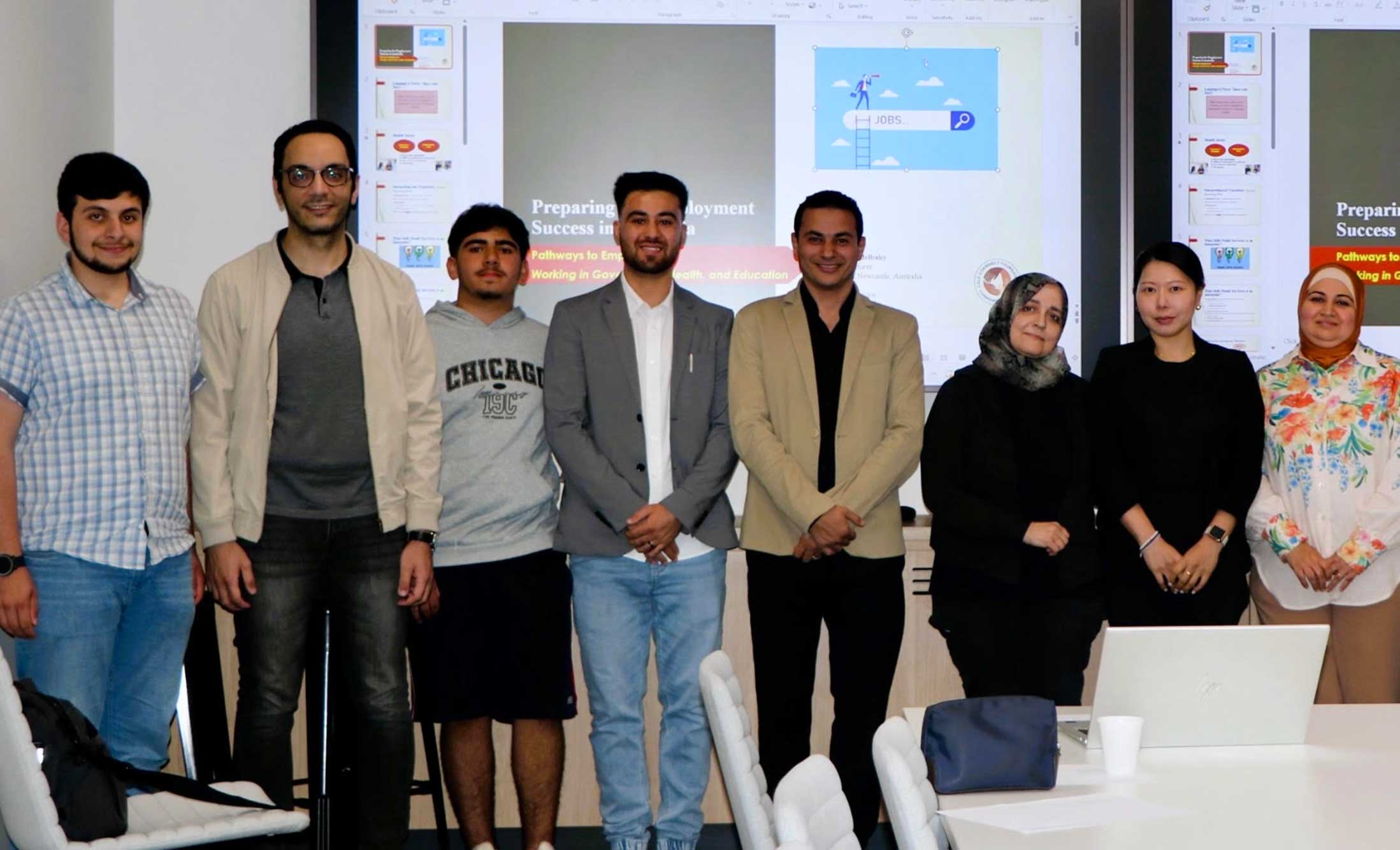 Unity Works participants stand with employers and partners, looking at the camera