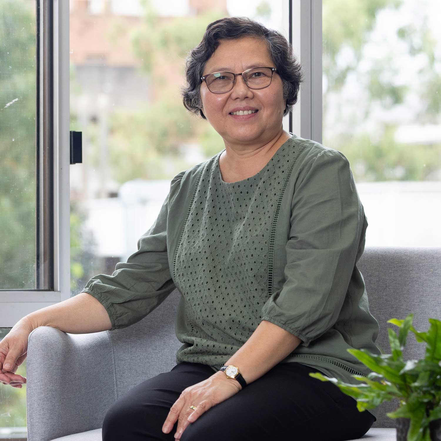 Brunette female wearing glasses, smiling and looking at the camera