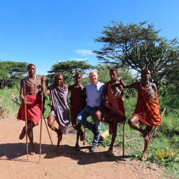 University of Newcastle student standing with Kenyan students. Endeavour Leadership Program to Kenya