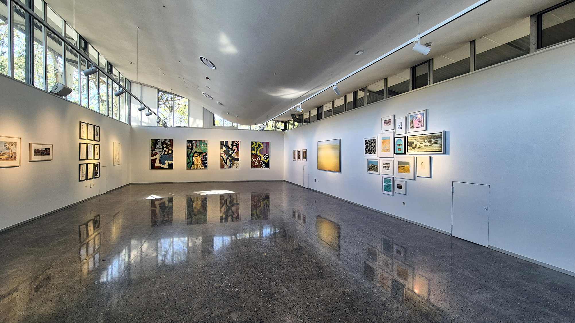 Image showing a collection of artworks, spread across a corner section inside the University Gallery.