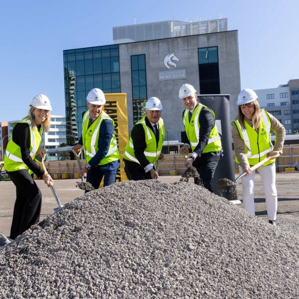 four people hold shovels and turn the first 'sod'
