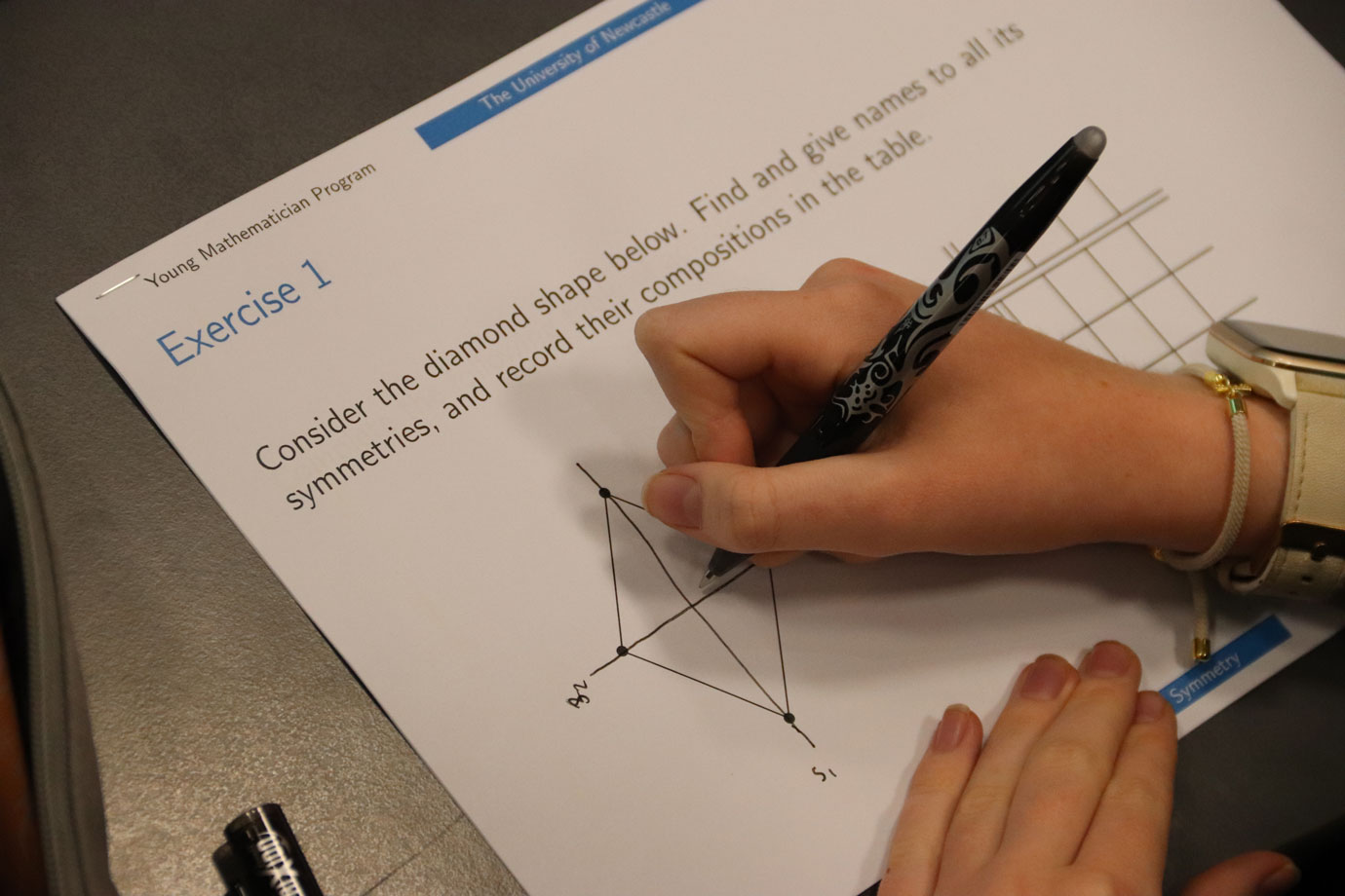 Student writes on a worksheet titled Exercise 1