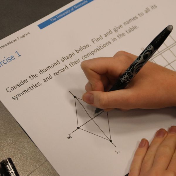 Student writes on a worksheet titled Exercise 1. Exploring where mathematics can take you in the Young Mathematicians Program