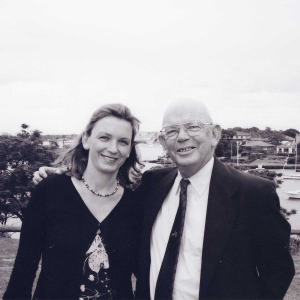 A black and white photo of a woman, Julie-Anne Edwards, standing with her late father, Robert (Bob) Edwards. Backing Research for Childhood Brain Cancer.