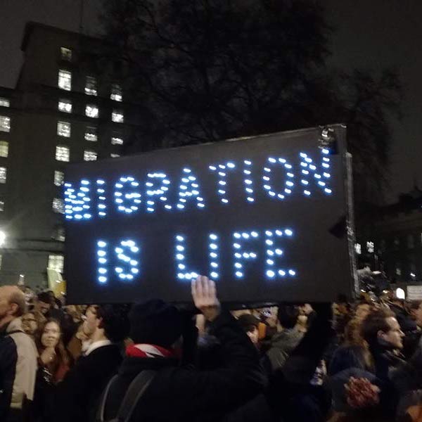 People protesting holding sign 'Migration is life'