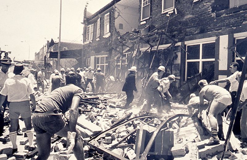Workers standing amid piles of rubble and demolished building debris in the Hamilton suburb of Newcastle, NSW, after the 1989 earthquake.