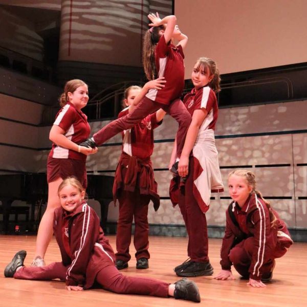 Group of primary school girls holding one girl in the air.. Birds of an opera perform together.