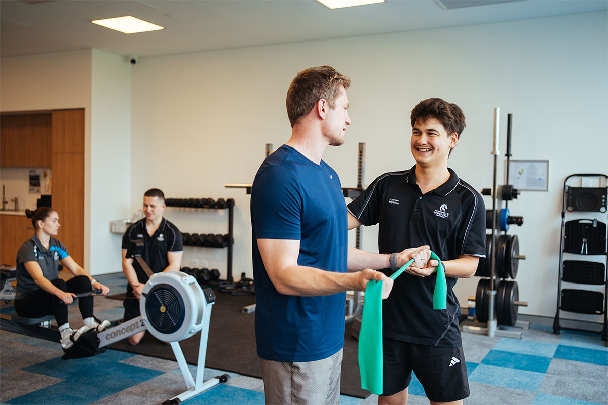 A personal trainer helping a man in a gym
